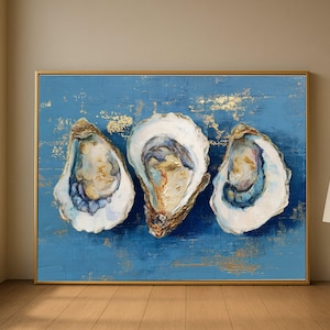 May include: An abstract painting features three open oyster shells against a textured blue background with gold leaf accents. The artwork is framed in a gold-colored rectangular frame, creating a coastal theme.