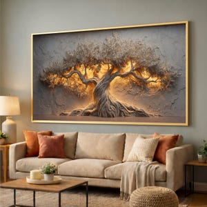 May include: A framed wall art piece featuring a textured, three-dimensional olive tree design. The tree has a gnarled trunk and branches with illuminated foliage, set against a gray background. The frame is gold, and the artwork hangs above a beige sofa.