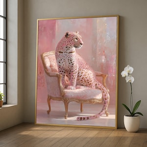 May include: A framed canvas art print depicting a pink leopard seated on a pink antique chair. The leopard has brown spots and is set against a pink and white background. The artwork is framed in a gold-coloured frame.