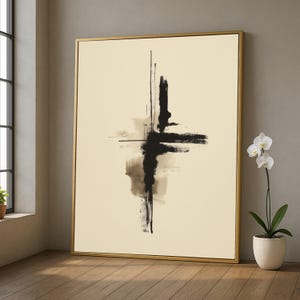 Op de afbeelding: Abstracte kunstprint met een zwart en bruin kruisvormig ontwerp op een crèmekleurige achtergrond, goud omlijst. Het kunstwerk wordt getoond in een kamer met een raam en een orchidee in pot.