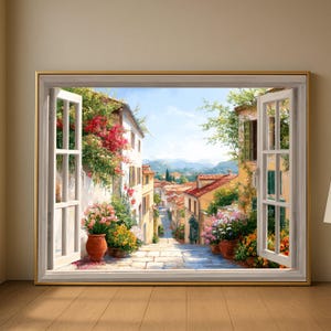 May include: A framed painting depicts a sunlit European street scene viewed through an open window. The artwork showcases a cobblestone street lined with buildings, vibrant flowers, and red-tiled roofs. The window frame is white with a gold border.