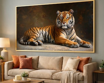 May include: A framed painting of a tiger lying down. The tiger has orange and black stripes and is set against a dark background. The frame is gold, and the painting is displayed above a beige sofa with orange pillows.