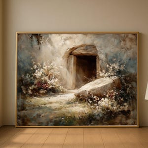 May include: A framed landscape painting showing a stone cave entrance. The artwork features a path leading to the entrance, surrounded by white flowers and greenery. The colour palette includes beige, brown, and blue tones.