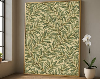 May include: A framed canvas art print featuring a repeating pattern of green leaves and branches on a cream background. The artwork is encased in a gold-colored frame and leans against a neutral-colored wall. A white orchid in a white pot is to the right.
