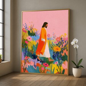 Puede incluir: Una impresión artística enmarcada representa una figura con una túnica naranja caminando por un campo de flores coloridas. El fondo es rosa suave y la obra de arte está en un marco dorado. El estilo es ilustrativo.