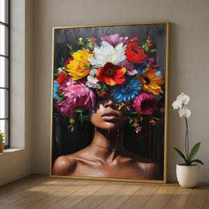 Könnte beinhalten: Ein gerahmtes Kunstwerk zeigt eine Frau mit einem farbenfrohen Blumenschmuck. Das Gemälde hat einen dunklen Hintergrund und einen goldenen Rahmen. Die Blumen sind eine Mischung aus Rot, Gelb, Rosa und Blau. Die Haut der Frau hat einen satten Braunton.