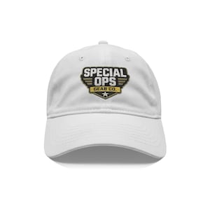 May include: White baseball cap with a curved brim. The cap features a black, gold, and white patch with the words "SPECIAL OPS" and "GEAR CO." The patch has a star at the bottom. The cap is made of a soft material.