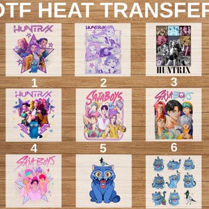 May include: A collection of nine DTF heat transfer designs featuring anime-style characters and blue cat creatures. The graphics include text labels like HUNTRIX and SAJABOYS, with colorful illustrations arranged in a grid on a wooden surface.