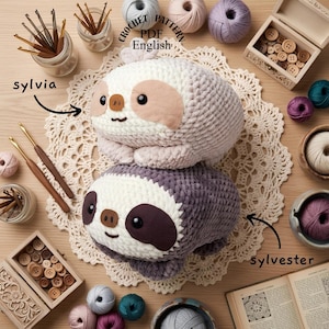 Puede incluir: Dos peluches de perezoso hechos de lana gruesa, uno color crema y otro gris oscuro, con caras de fieltro y ojos de seguridad negros. La imagen incluye el texto Crochet Pattern PDF English, Sylvia y Sylvester, rodeados de ganchillos y ovillos.