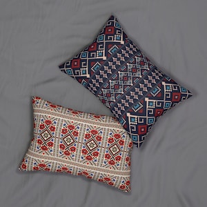 May include: Two decorative throw pillows with patterned designs. One pillow features a navy blue background with a geometric pattern in red, light blue, and white. The other pillow has a cream background with a floral and geometric pattern in red, brown, and blue.
