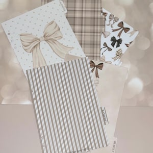 May include: A set of planner inserts featuring various designs including a large beige bow on a white polka dot background, a brown plaid pattern, a white sheet with brown bows, and a brown and white striped sheet with the text The Golden Journal Co.