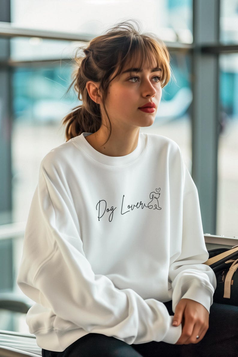 May include: White sweatshirt with the text "Dog Lover" in a script font, accompanied by a small dog illustration. The sweatshirt is a casual style, suitable for everyday wear.