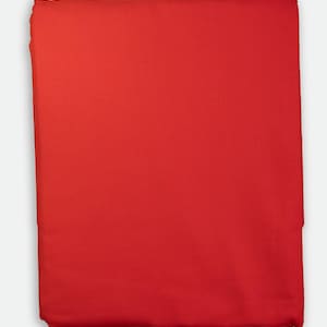 May include: A folded, solid red fabric, likely a textile or cloth. The material appears smooth and evenly colored, with a slight sheen. The edges are neatly folded, suggesting a finished product or a piece ready for use in sewing or crafting.