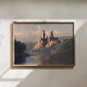 Può includere: Dipinto paesaggistico incorniciato raffigurante un castello su una scogliera che si affaccia su un corso d'acqua. Il castello ha più torri e guglie. Il cielo è un misto di blu e giallo, con uccelli che volano sopra. Il dipinto è in una cornice di legno.