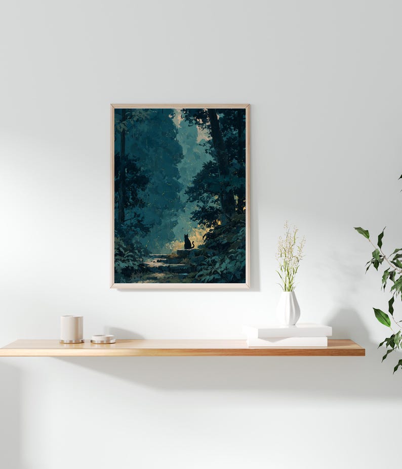 May include: A framed art print showing a forest scene with a black cat silhouette on a stone path. The artwork uses blues and greens, with light filtering through the trees. The print is displayed on a wooden shelf.