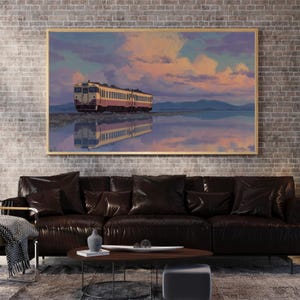 May include: A framed artwork depicts a train reflected in water under a colorful sky. The train is yellow and red, set against a backdrop of mountains and a sunset with pink and purple hues. The artwork is displayed above a dark brown leather sofa.