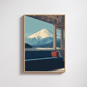 Pode incluir: Impressão artística emoldurada retratando o Monte Fuji visto de um trem. A obra apresenta um assento azul, uma bolsa laranja e um céu limpo. A montanha está coberta de neve e a paleta de cores é suave.