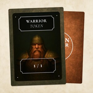 Peut inclure: Une carte « Warrior Token » avec une illustration détaillée d'un guerrier barbu en armure, le texte « WARRIOR TOKEN » et « 1/1 » sont affichés. Une deuxième carte avec un fond marron et du texte blanc est visible.