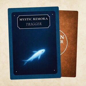 May include: Two playing cards. The front card is dark blue with the text "MYSTIC REMORA TRIGGER" above a glowing white fish illustration. The back card is brown with a white circular design and the letters "N R".