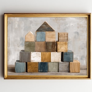 May include: A framed artwork featuring a wooden block structure resembling a house. The blocks are various colors, including blue, brown, and white. The background has a textured, neutral color palette, and the frame is gold.