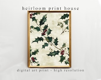 May include: A framed digital art print featuring a watercolor holly design with green leaves and red berries. The print has a vintage aesthetic and is set against a cream-colored background. The frame is a warm, light brown color. Text at the top reads "heirloom print house".