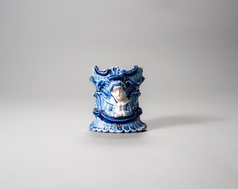 Encantador portacerillas antiguo de color azul cobalto y blanco con figura de marinero