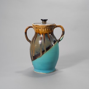 Jarrón de cerámica vintage con tapa, de gres con esmalte goteante en tonos marrón y turquesa, con asas.
