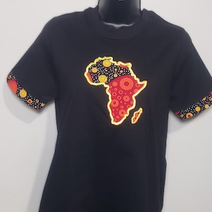 May include: Black t-shirt featuring a colorful map of Africa. The map is outlined in yellow and filled with red and orange patterns. The sleeves have matching patterned cuffs. The shirt is displayed on a black mannequin.