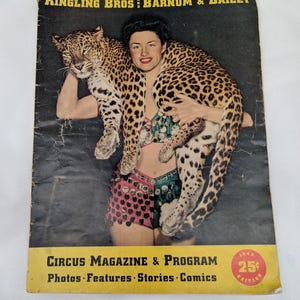 May include: A 1946 Ringling Bros and Barnum & Bailey Circus Magazine & Program featuring a person in a sequined outfit holding a leopard. The cover includes the text: Photos, Features, Stories, Comics, and a red 25 cent edition badge.