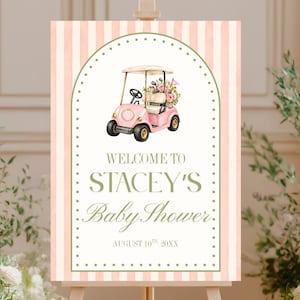 Puede incluir: Un letrero rectangular vertical con fondo de rayas rosa claro y blanco que presenta un marco arqueado. Muestra una ilustración de un carrito de golf rosa con flores y el texto: WELCOME TO STACEY'S Baby Shower AUGUST 10TH 20XX.