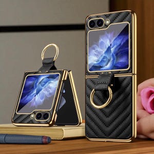May include: Black and gold phone cases with a quilted design. The cases are for a foldable phone, featuring a ring holder and a gold frame. The phone screens show a blue floral image.