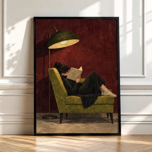 Puede incluir: Una impresión de arte mural enmarcada que representa a una persona con cabello oscuro en un moño, vistiendo un suéter y falda negros, sentada en un sillón verde lima mientras lee un libro. Una lámpara de pie dorada con pantalla verde ilumina.