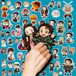 May include: A collection of numerous small, colorful vinyl stickers featuring various chibi-style anime characters from Demon Slayer, including Tanjiro and Nezuko, arranged on a solid teal background with a hand visible in the foreground.
