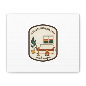 May include: A canvas print featuring a retro-style patch design. The patch reads "Indoorsy National Park" and depicts a couch, lamp, plant, and campfire. The words "couch ranger" are at the bottom of the patch.