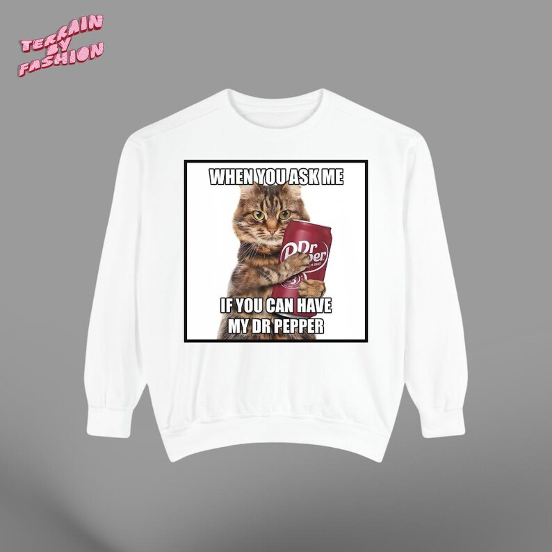 May include: White sweatshirt featuring a graphic of a cat holding a Dr. Pepper can. The text on the graphic reads "WHEN YOU ASK ME IF YOU CAN HAVE MY DR PEPPER". The sweatshirt has a crew neck and long sleeves.
