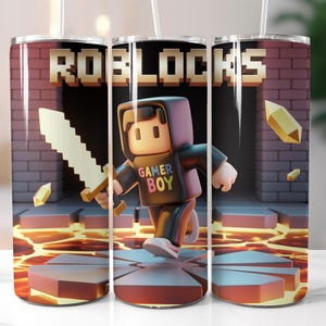 May include: A tumbler featuring a video game theme. The design includes a pixelated character holding a sword, with the text "GAMER BOY" on the character's shirt. The background shows a brick wall and lava.