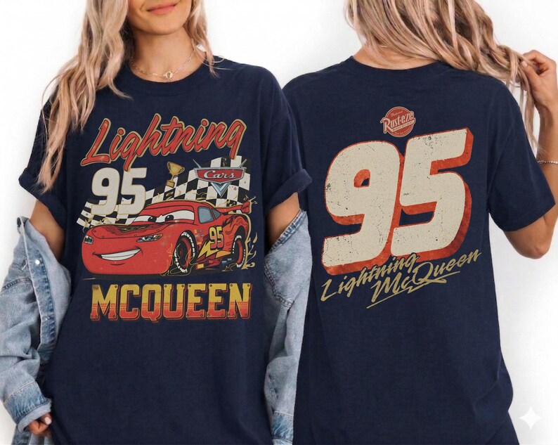 May include: Navy blue t-shirt featuring a graphic of Lightning McQueen from the Cars movie. The front design includes the text "Lightning 95 McQueen" with a red race car. The back of the shirt displays the number "95" and "Lightning McQueen".