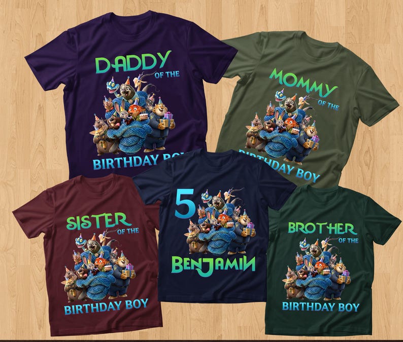 May include: Five short-sleeved t-shirts in various colors, including purple, green, and burgundy. Each shirt features a cartoon graphic of animal characters and text such as "Daddy", "Mommy", "Sister", "Brother", and "Benjamin".
