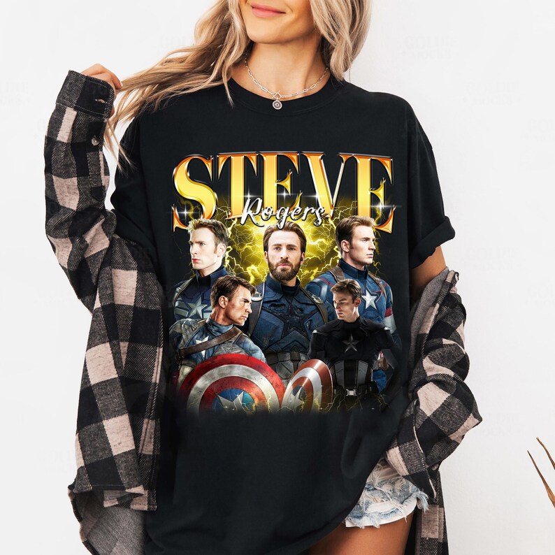 May include: Black t-shirt featuring multiple images of Steve Rogers, with the name "STEVE Rogers" in gold lettering. The design includes images of the character in various poses, holding a shield.