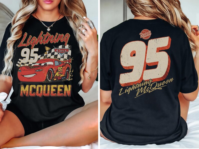May include: Black t-shirt featuring a graphic of Lightning McQueen from the Cars movie. The front design includes the number 95, the words "Lightning McQueen," and a checkered flag. The back of the shirt displays the number 95 and the words "Lightning McQueen."