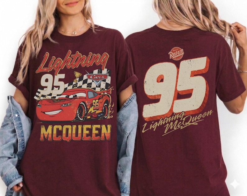 May include: Burgundy t-shirt featuring a graphic of Lightning McQueen from the Cars movie. The front design includes the text "Lightning 95 McQueen" with a checkered flag and a smiling red race car. The back of the shirt displays a large "95" and "Lightning McQueen".