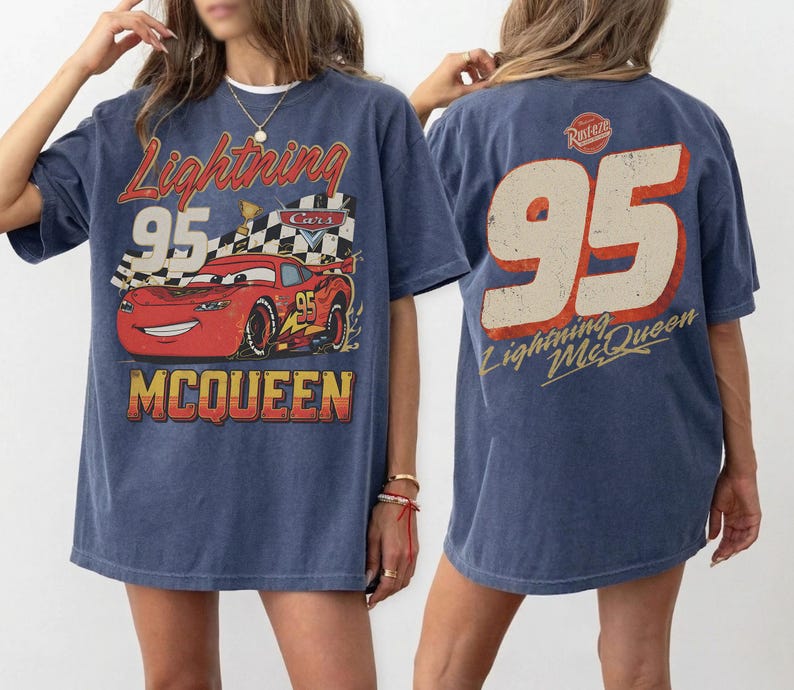 May include: A blue t-shirt featuring a graphic of Lightning McQueen from the Cars movie. The front design includes the text "Lightning 95 McQueen" with a red race car. The back of the shirt displays a large "95" and "Lightning McQueen".