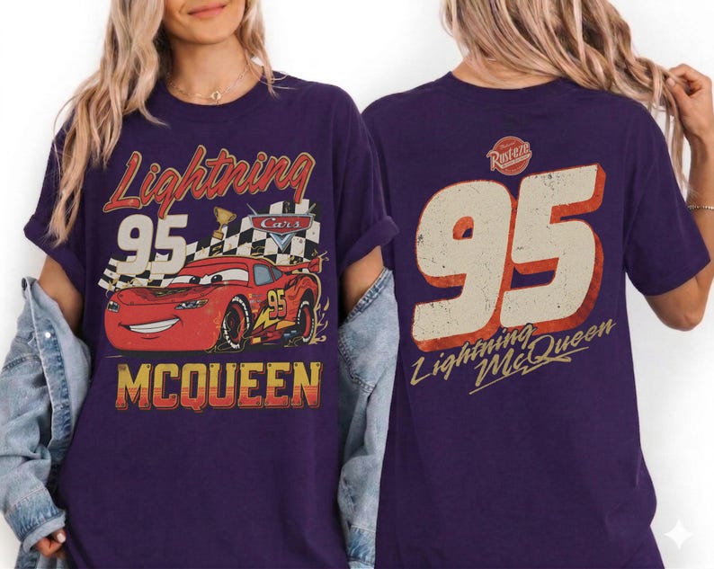 May include: Purple t-shirt featuring a graphic of Lightning McQueen from the Cars movie. The front design includes the number 95, the text "Lightning McQueen," and a checkered flag. The back of the shirt also displays the number 95 and the text "Lightning McQueen."
