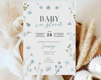 Puede incluir: Una invitación para un baby shower con el texto "BABY in bloom" y detalles del evento. La invitación presenta un diseño floral con flores azules y vegetación. La invitación incluye el nombre "Lorenzo" e información de RSVP.