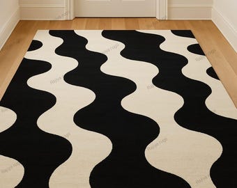 May include: A rectangular rug with a bold, wavy pattern in black and cream. The design features large, flowing curves that create a striking visual contrast. The rug is placed on a wooden floor, enhancing its decorative appeal.