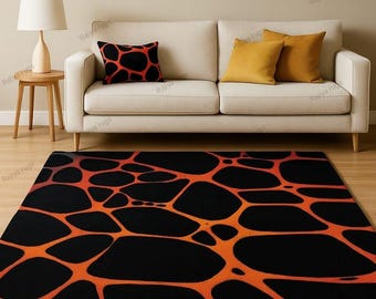 May include: A black and orange area rug with an abstract, organic pattern dominates the foreground. The rug's design features interconnected orange lines against a black background. A cream-colored sofa with throw pillows and a wooden side table with a lamp are also visible.