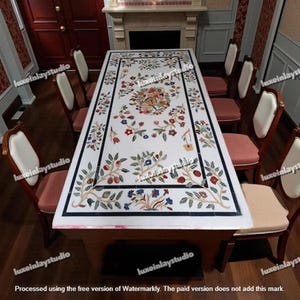 Puede incluir: Una mesa de comedor rectangular de mármol blanco con diseño floral incrustado, rodeada de ocho sillas de madera. La mesa presenta un borde negro y intrincados patrones florales. Las sillas tienen respaldos color crema y cojines rosas.