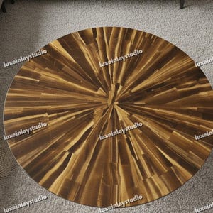 Puede incluir: Una mesa de centro redonda con un diseño único de rayos de sol. La superficie de la mesa está hecha de piezas de madera en tonos marrones y beige, que irradian desde el centro. La mesa tiene un acabado pulido y el diseño general es moderno y llamativo.