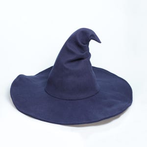 Op de afbeelding: Een donkerblauwe heksenhoed met een brede, ronde rand en een hoge, puntige kroon die aan de bovenkant licht gebogen is. De hoed is gemaakt van een effen gekleurde stof met een gladde, matte afwerking en een gestructureerde, rechtopstaande vorm.