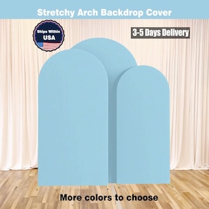 May include: Three light blue stretchy arch backdrop covers. The covers are arranged in a row, with the tallest in the middle. Text at the top reads "Stretchy Arch Backdrop Cover." The bottom text says "More colors to choose."